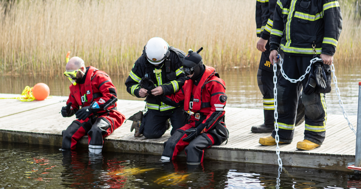 Brandmän vid sjö.